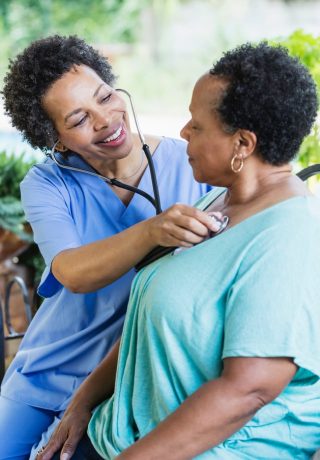 A nurse hugs an elderly patient.