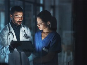 A doctor and a nurse look at a tablet.