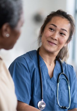 A female nurse smiles at a patient.
